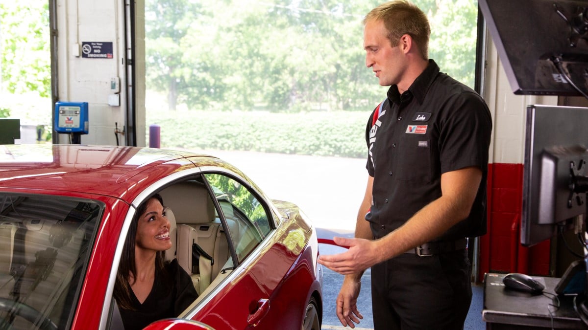 Valvoline CSR explains oil types to guest in her car at Valvoline Instant Oil Change