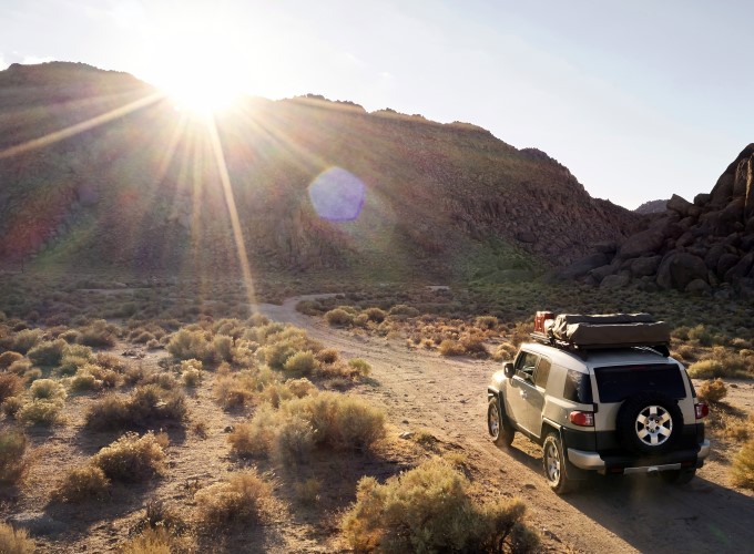 Summer sun basking down on SUV driving through desert